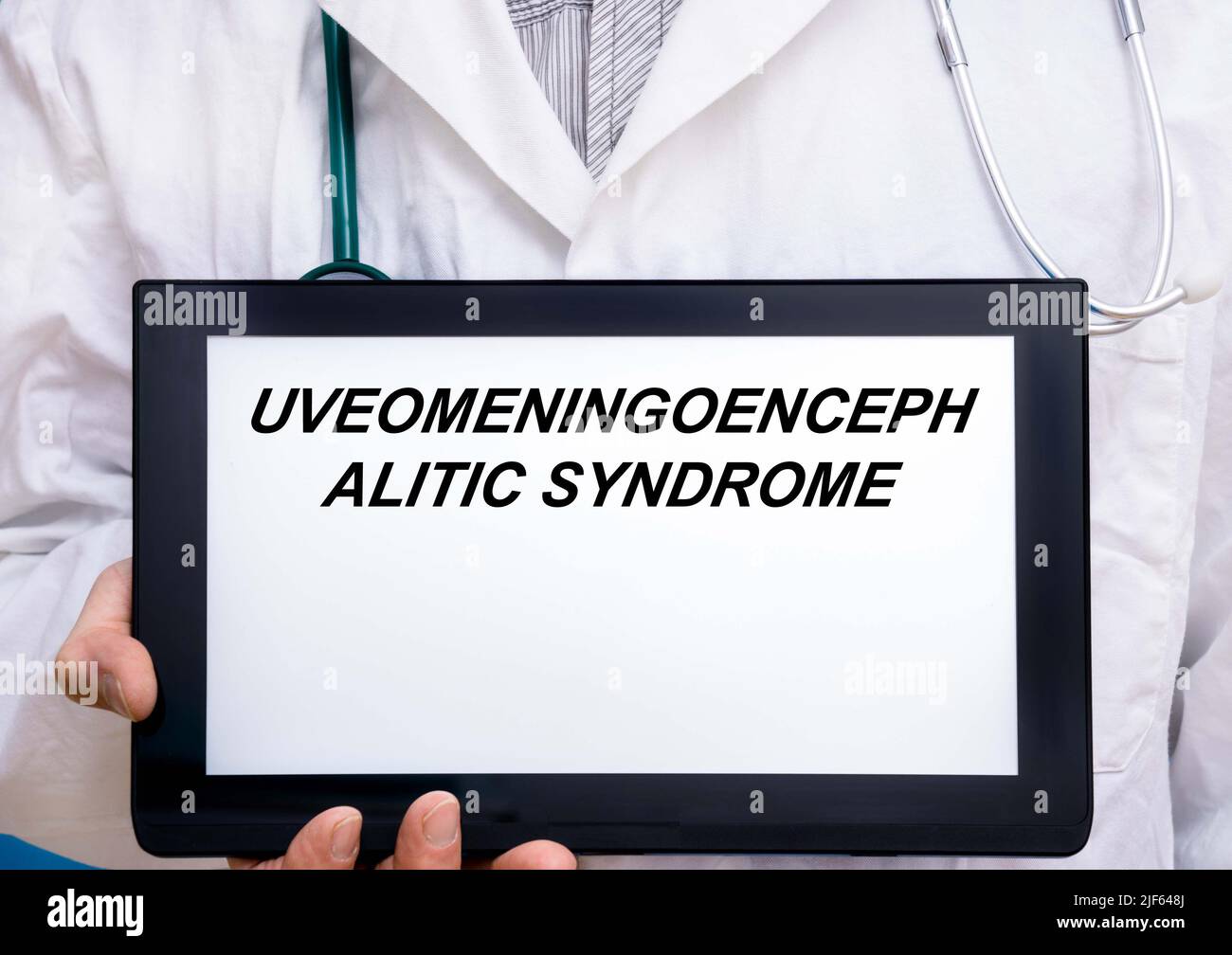 Uveomeningoencephalitic Syndrome.  Doctor with rare or orphan disease text on tablet screen Uveomeningoencephalitic Syndrome Stock Photo