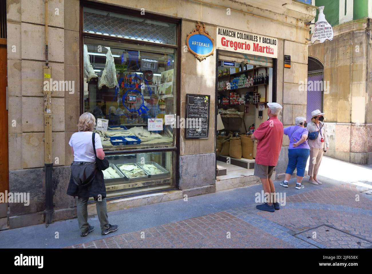Tourists admire the window display of Gregorio Martin, a traditional salted cod shop on Artekale in the old town of the Spanish city of Bilbao Stock Photo