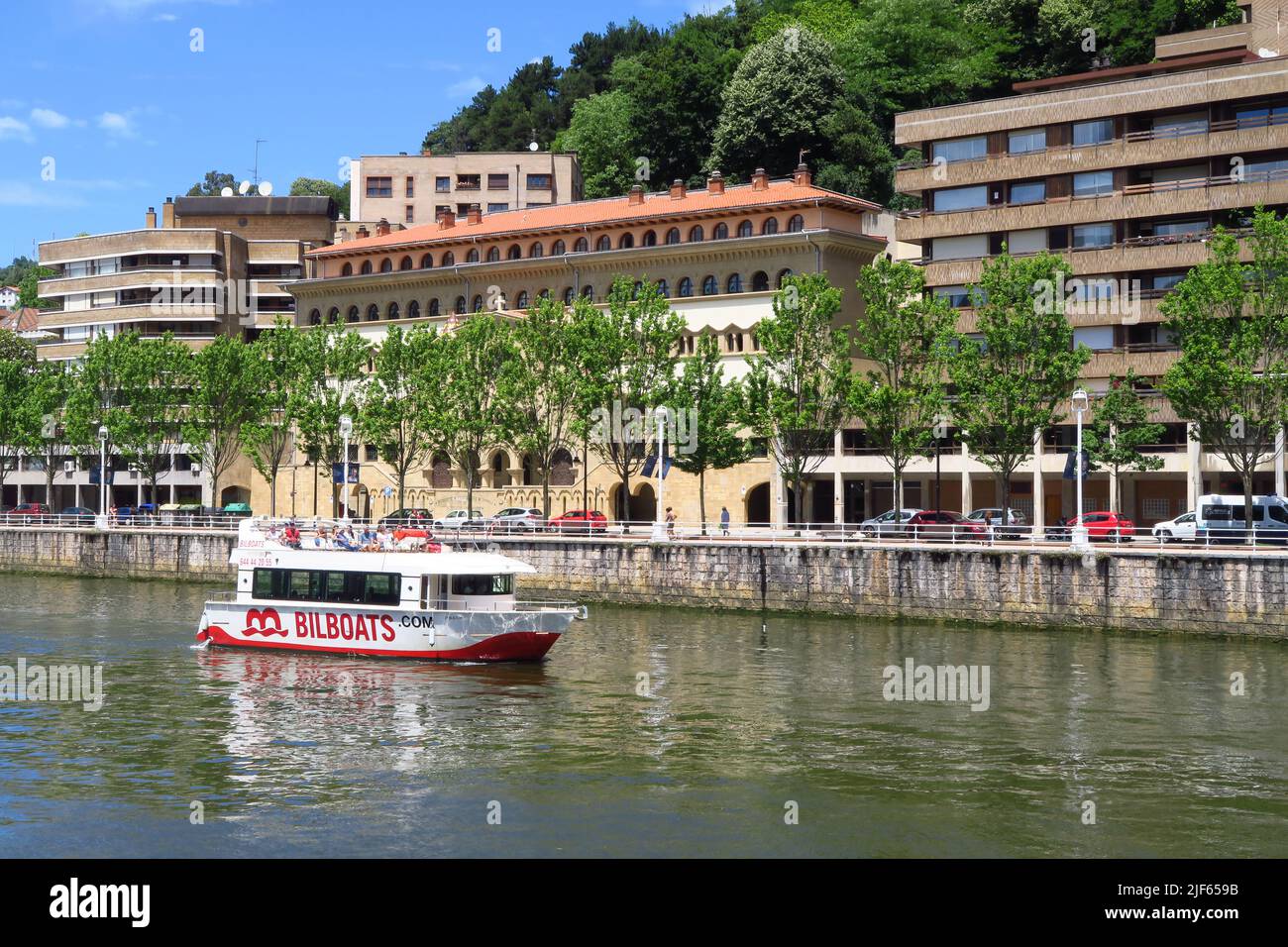 A tourist boat sailing upriver in the Spanish city of Bilbao Stock Photo