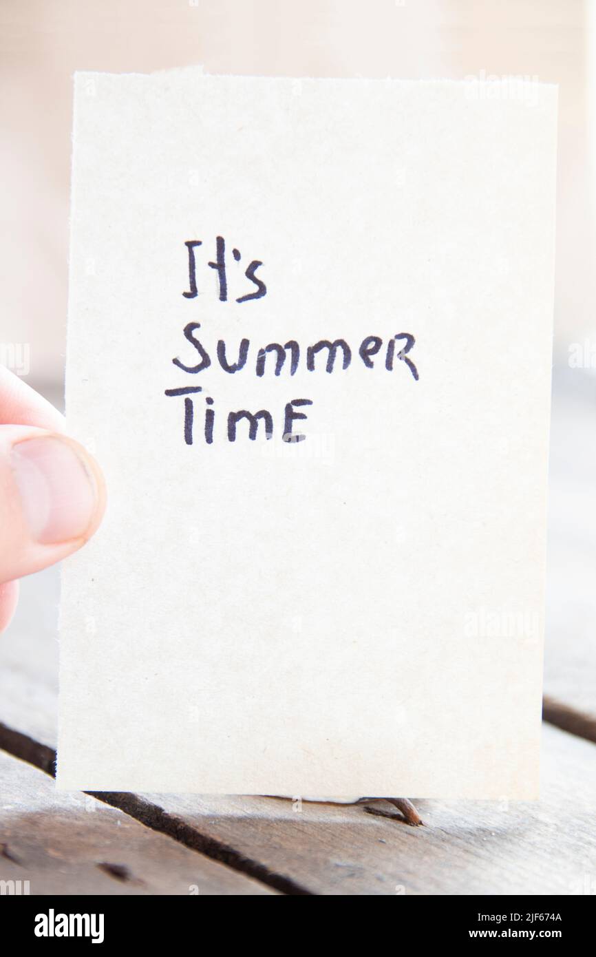It's summer time concept. The hand holds a sign with the inscription. Stock Photo