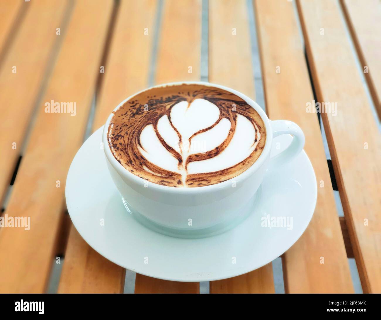 High angle Latte art coffee on wooden table in coffee shop Stock Photo