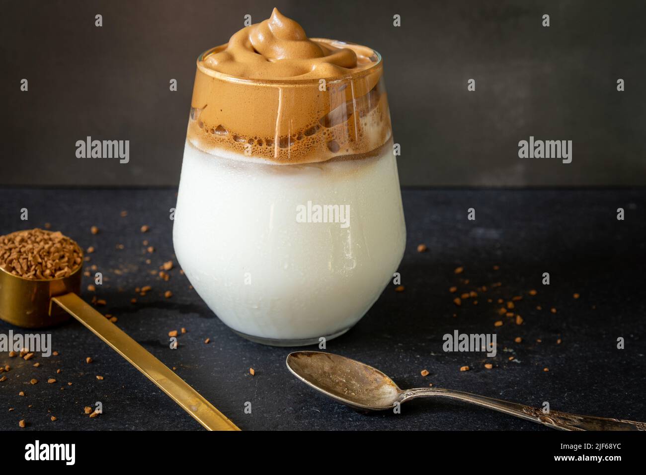 Dalgona coffee. Korean style coffee ice drink on dark background. Instant coffee whipped with sugar and water for tasty breakfast. Very fashionable co Stock Photo