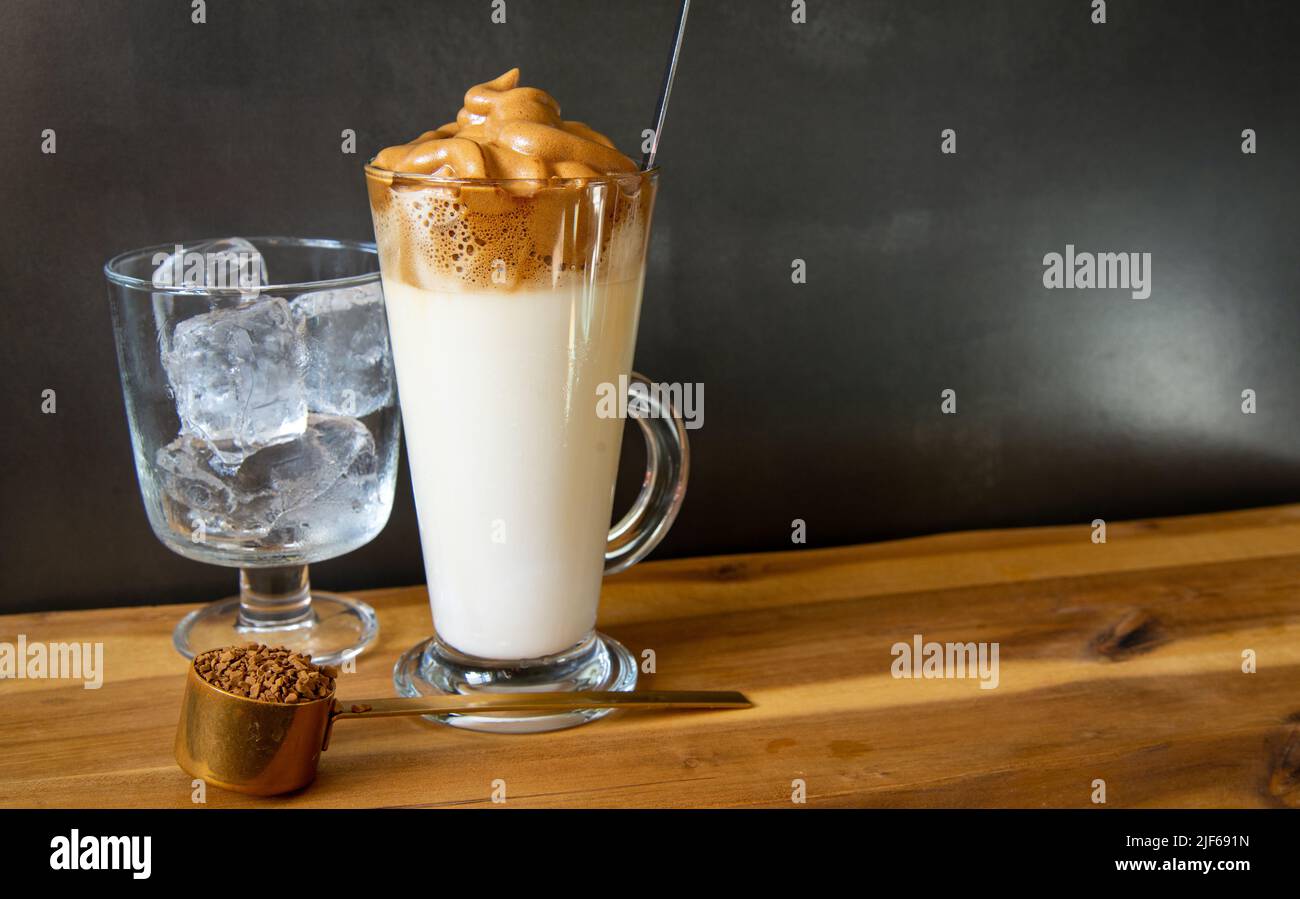Dalgona coffee. Korean style coffee ice drink on dark background