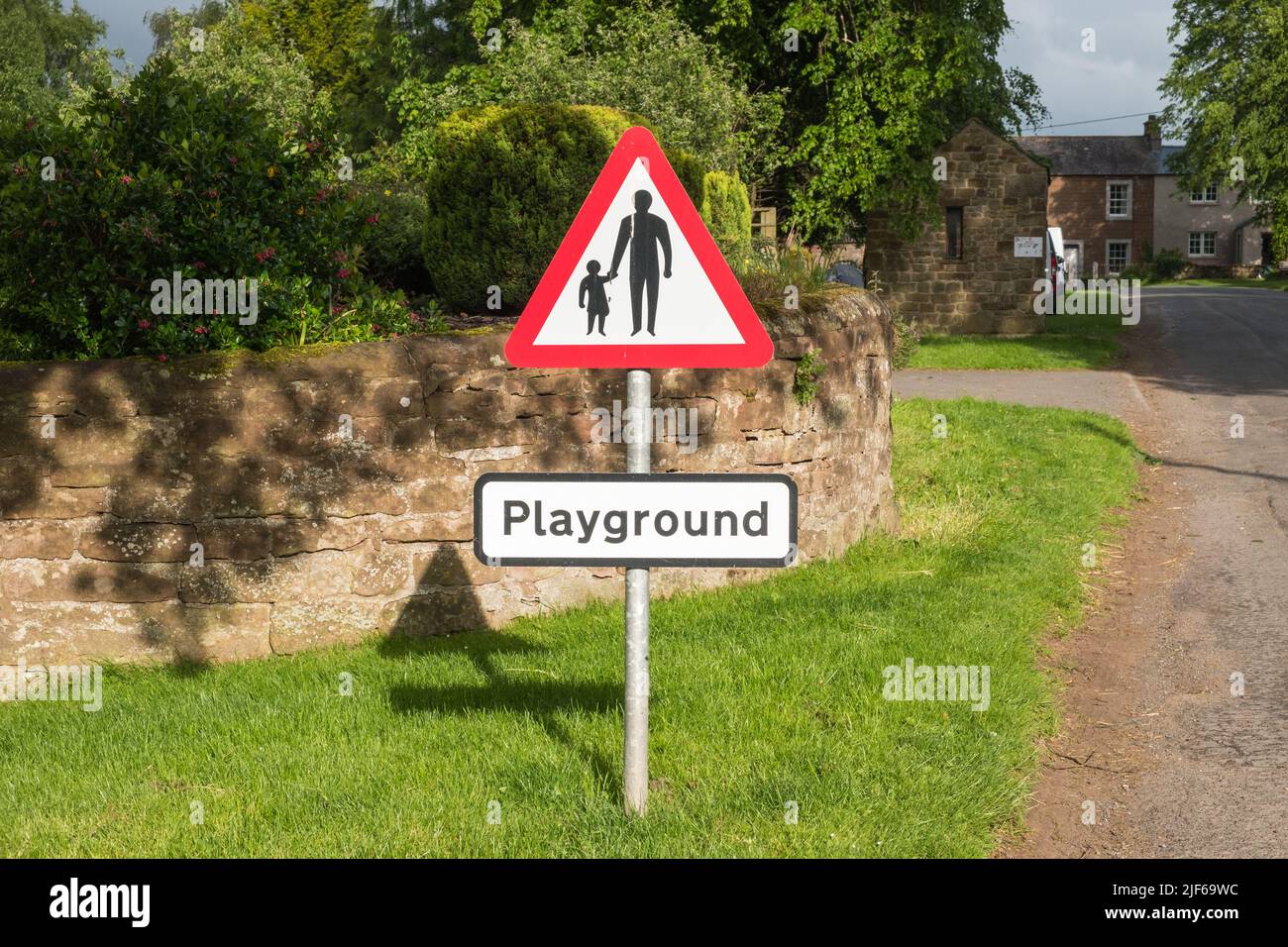 Red warning triangle sign for children playground in the village of Dufton near Appleby-in-Westmorland, Cumbria Stock Photo