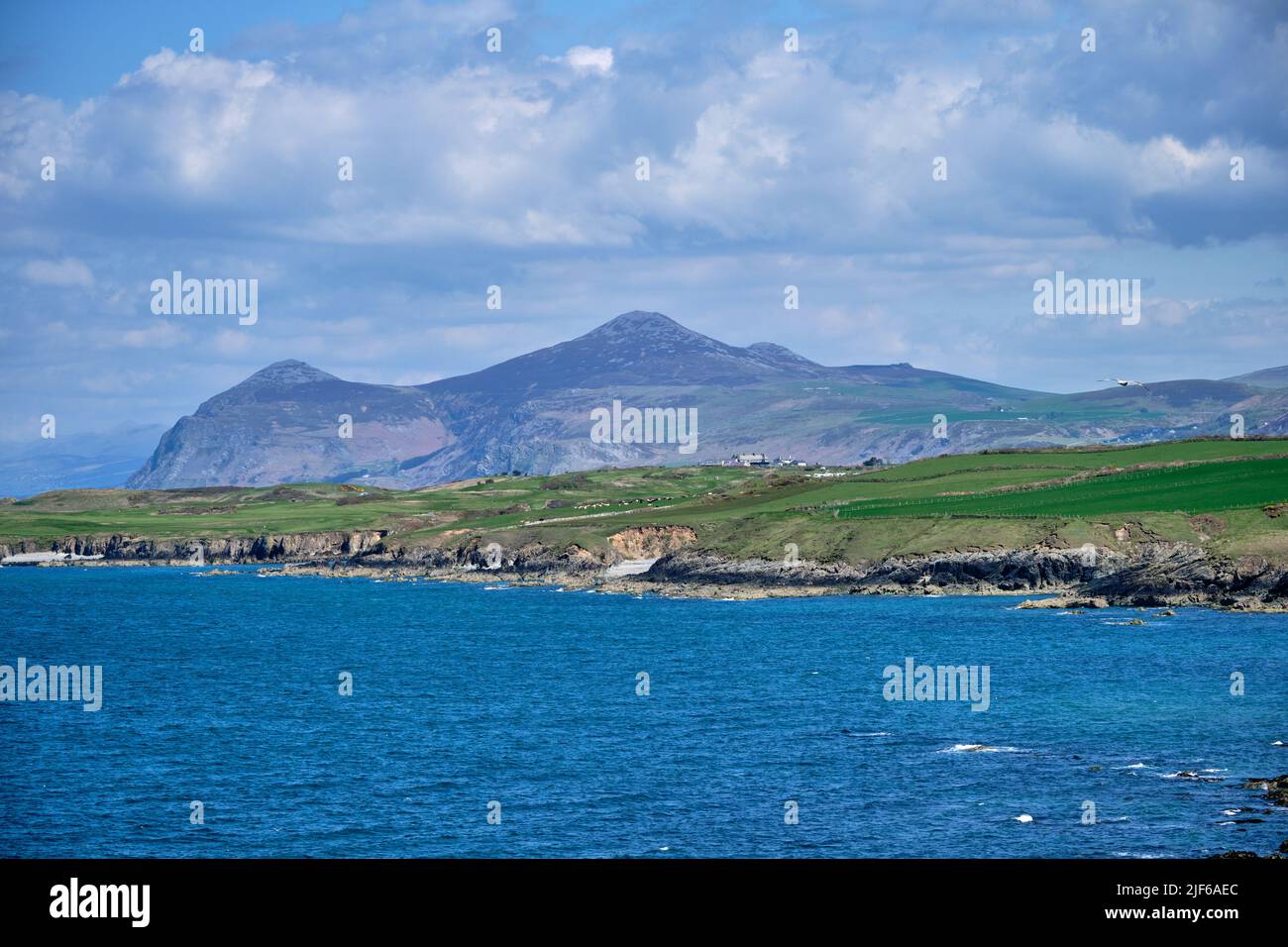 A view looking towards Yr Eifl on the Llyn Peninsula over the Porth Dinllaen peninsula and Nefyn Golf Club from the Wales Coast Path. Stock Photo