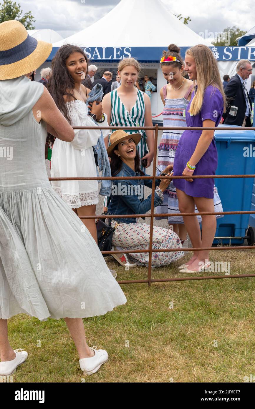 Henley, Oxfordshire, England, UK 29 June 2022 Day at Henley Royal Regatta. A mother cuts her daughters hem to the knee to adhere to the dress code Stock Photo