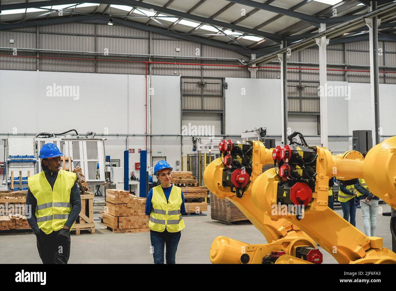 Industrial engineers working inside robotic factory - Focus on robot machine Stock Photo