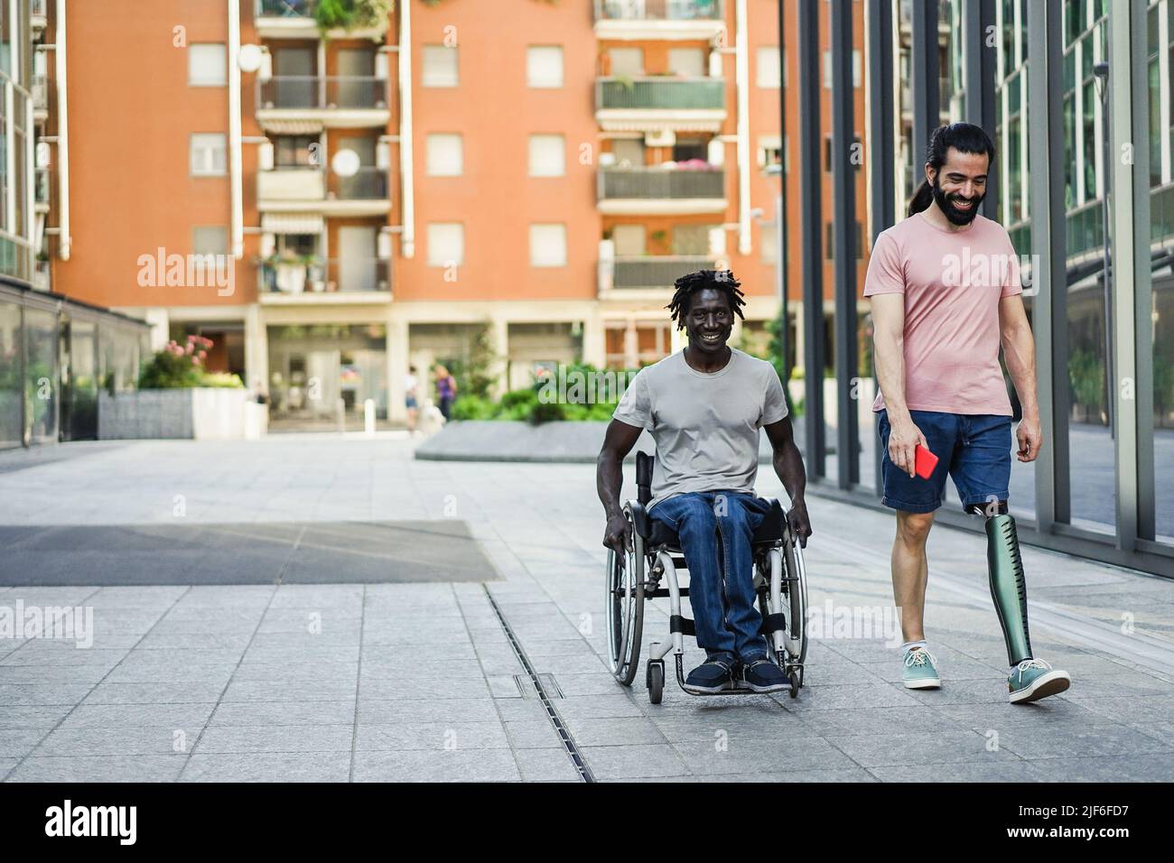Multiracial friends with disability having fun outdoor - Focus on prosthetic leg Stock Photo