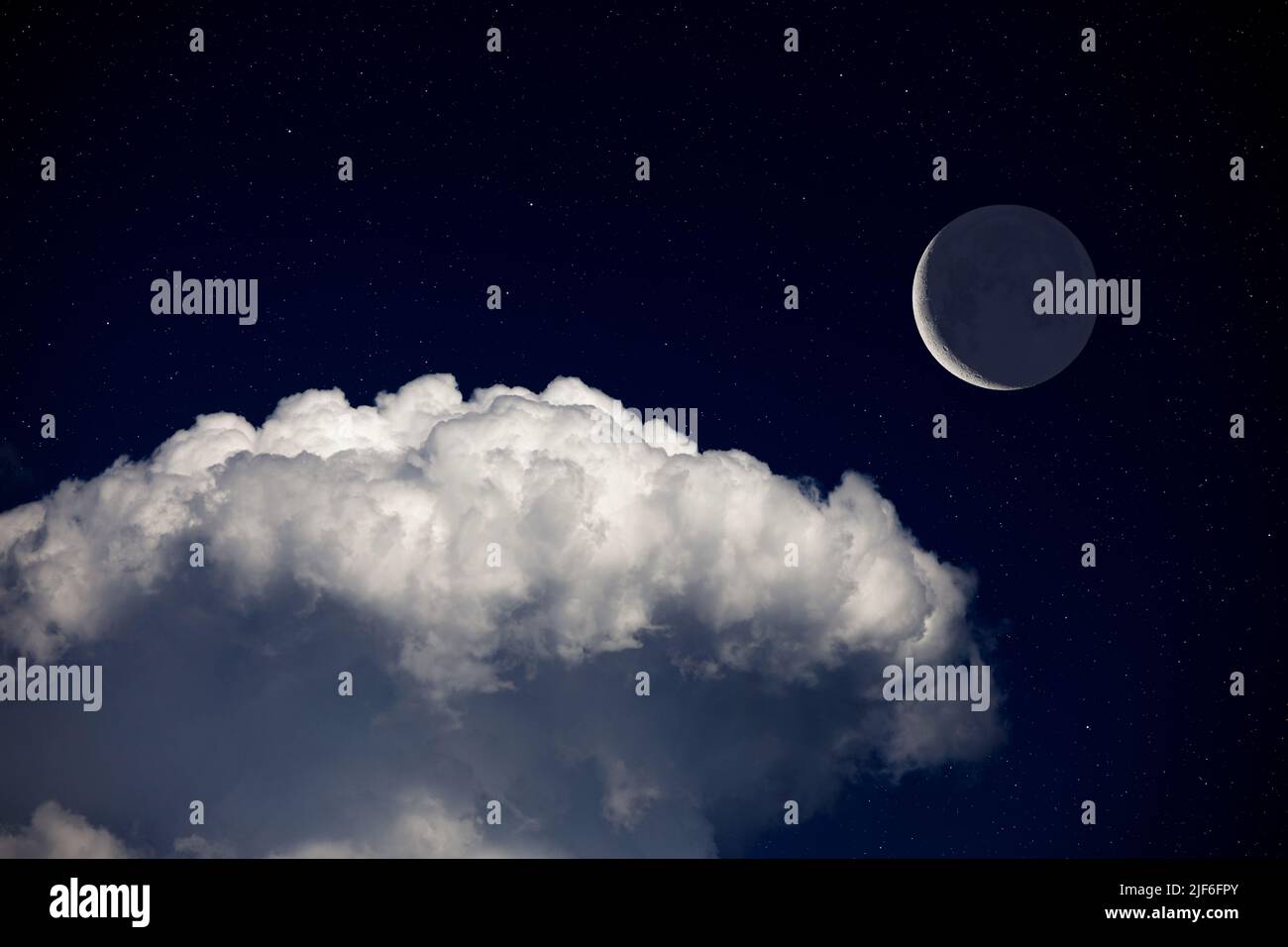 Fantasy night landscape, waning crescent moon surrounded by stars above cloud. Daydreaming image. Stock Photo