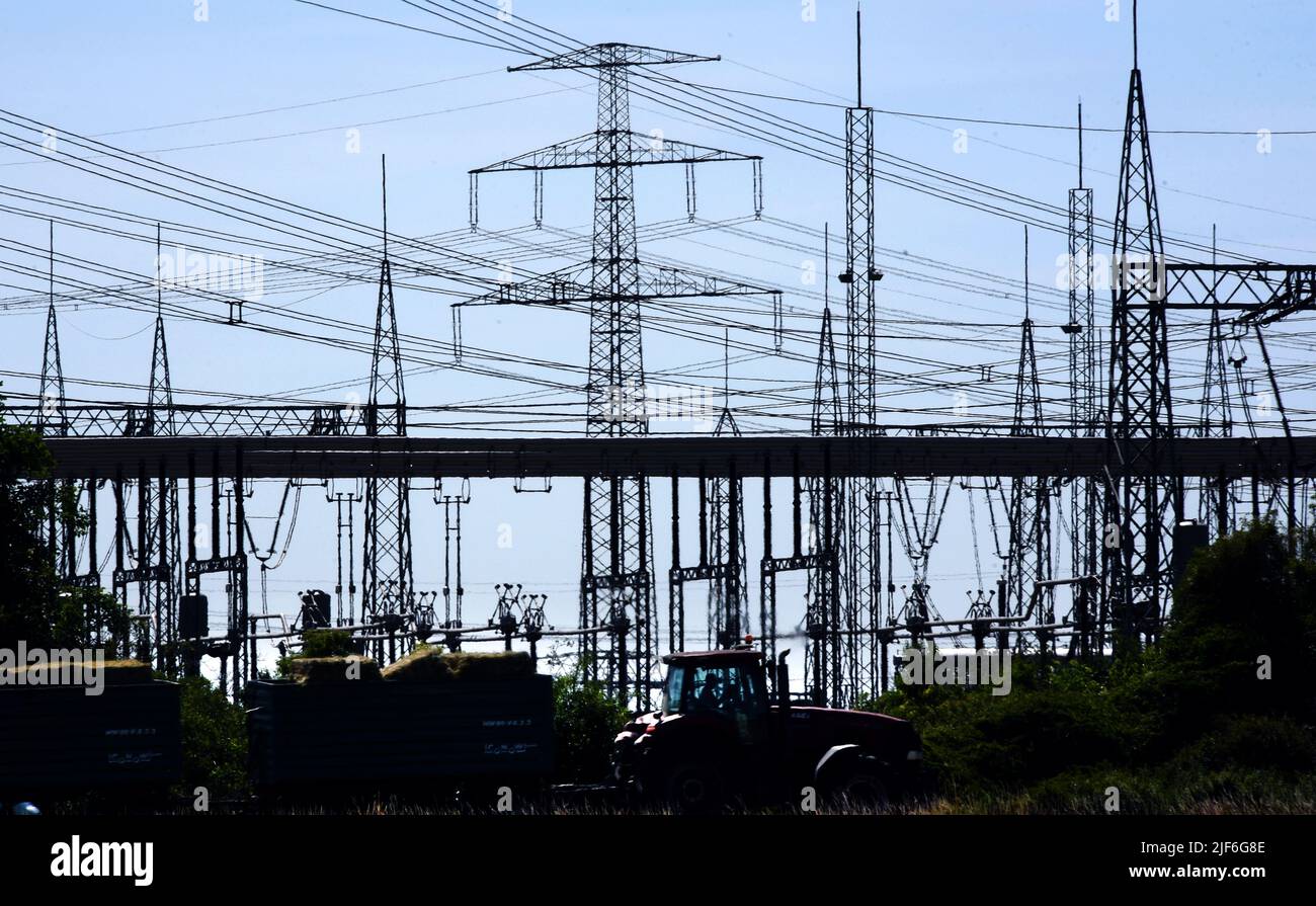 22 June 2022, Saxony-Anhalt, Bad Lauchstädt: Along a trunk road, the facilities of the Bad Lauchstädt substation can be seen standing out against the blue sky. The substation is one of over 70 electricity hubs operated by the transmission system operator 50Hertz in eastern Germany and needs to be expanded in the course of the energy transition. Two so-called STATCOMs. are being built here to collect electricity from renewable energies, transform it to a higher voltage level and transport it to other regions via extra-high voltage lines. The high-tech facilities are intended to keep the voltage Stock Photo