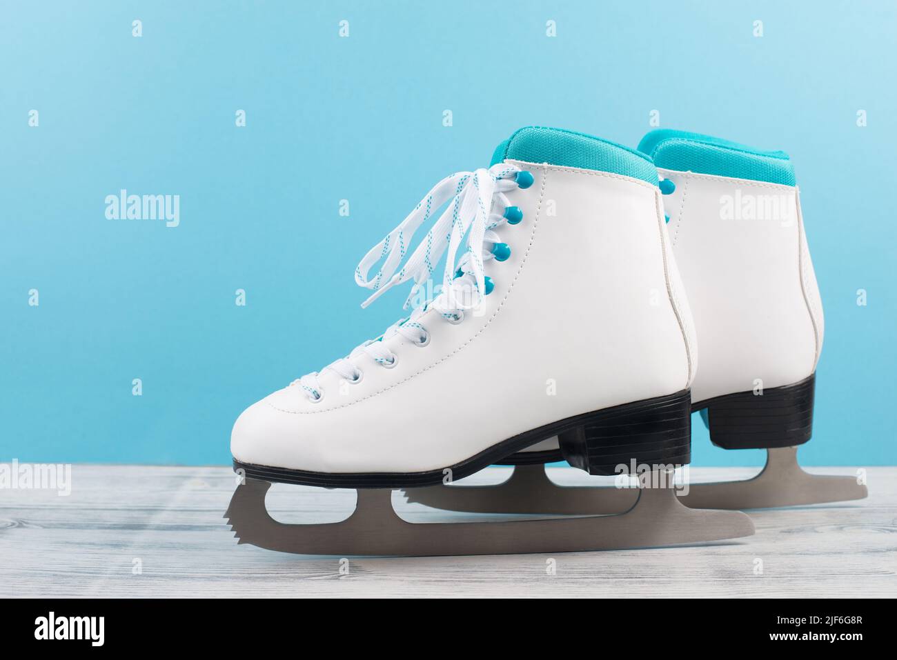 Pair of ice skaters in front of a blue background, winter sport