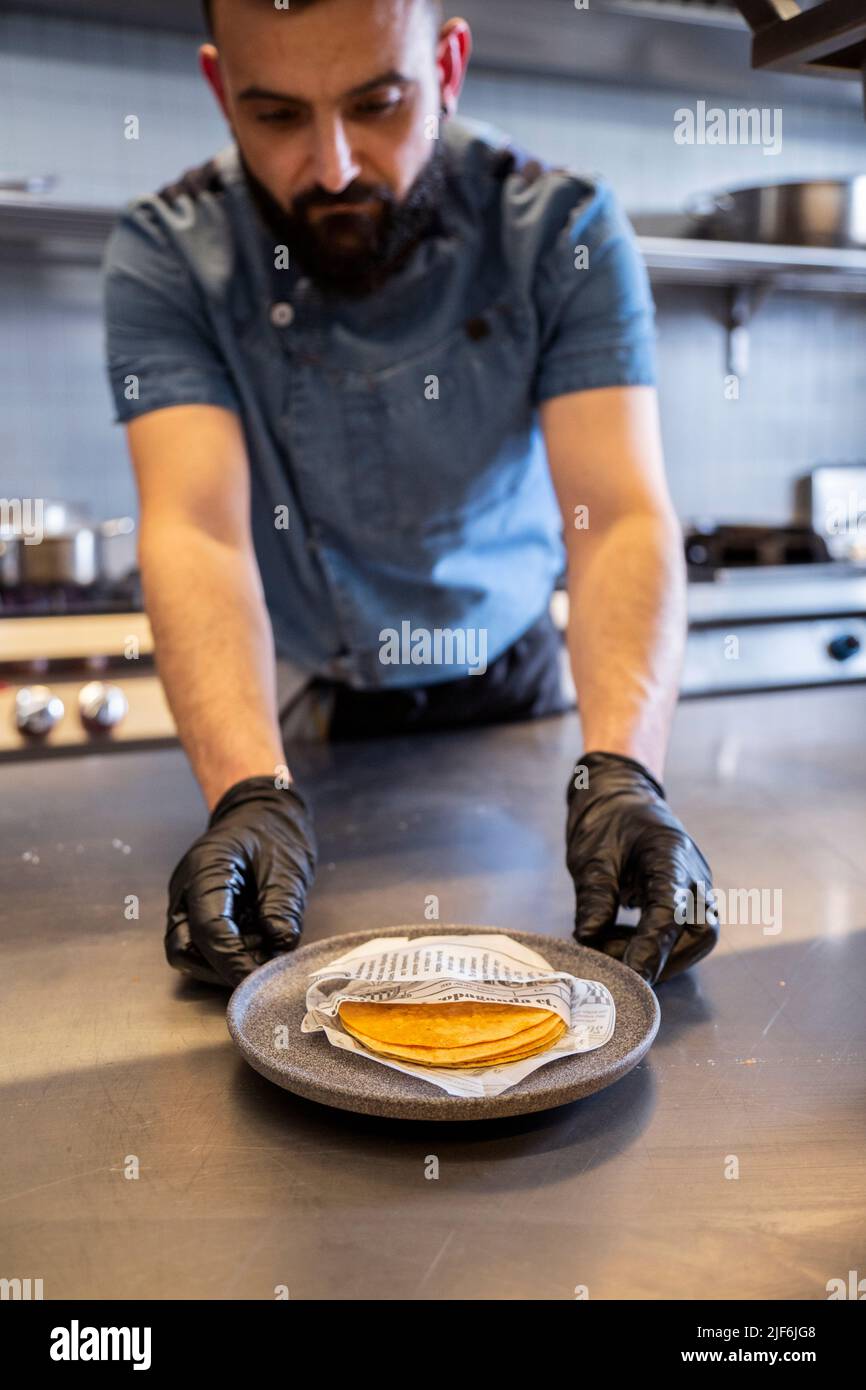Anonymous Male chef arranging tortillas on kitchen counter in ...