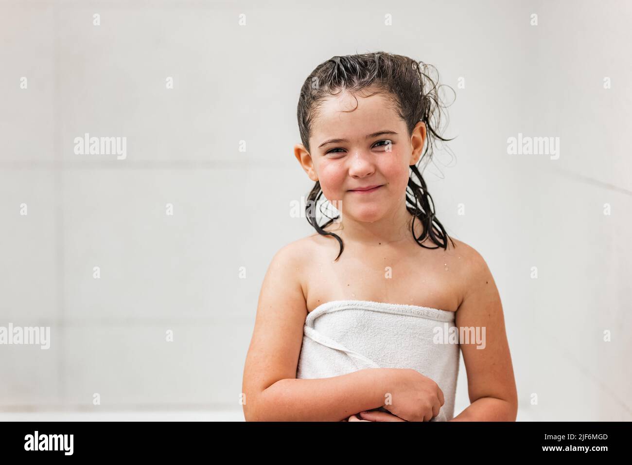 Portrait of girl with wet hair wearing towel after bathing while
