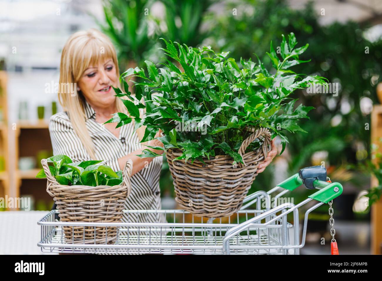Elderly female customer in smart casual clothes with long blond hair