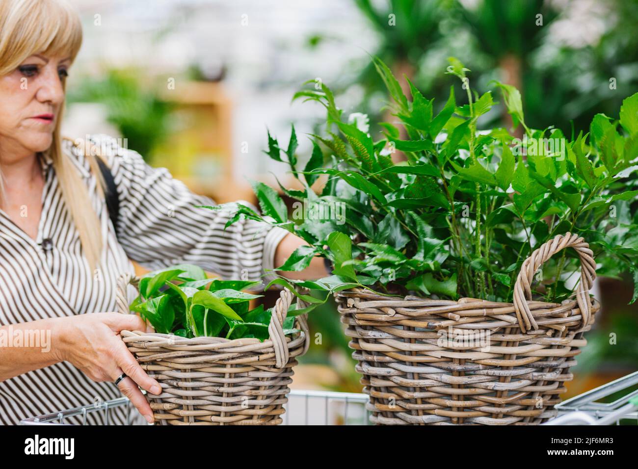 Elderly female customer in smart casual clothes with long blond hair