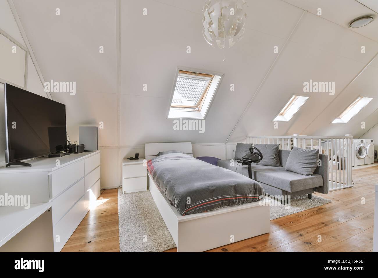 Interior of contemporary bedroom with white walls and tv in attic of ...