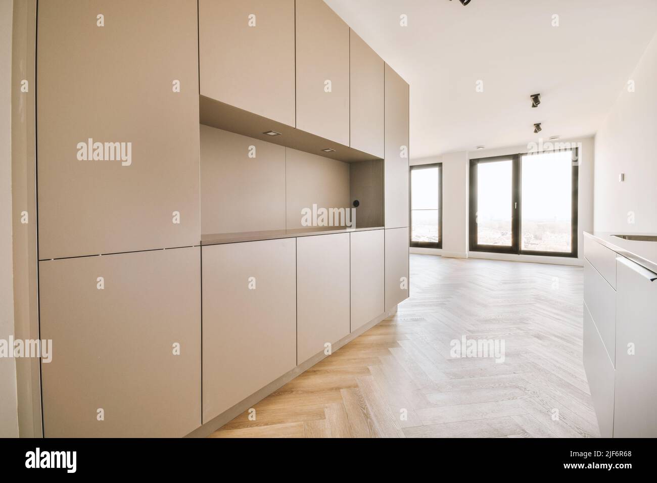 Interior of empty white kitchen with windows and wooden parquet floor ...