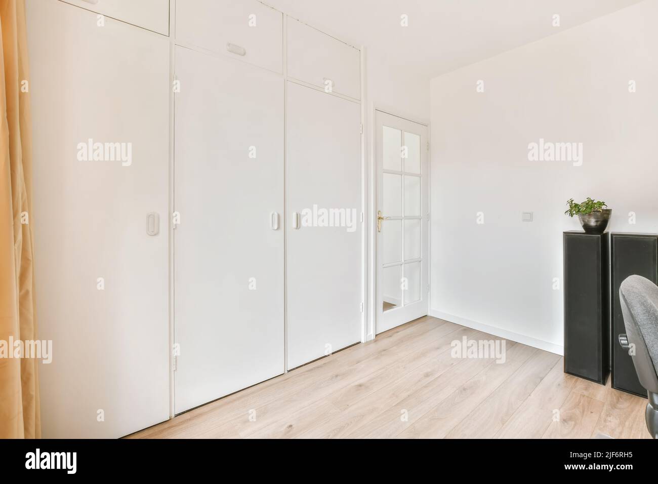 White doors of big closet placed in light spacious room with glass