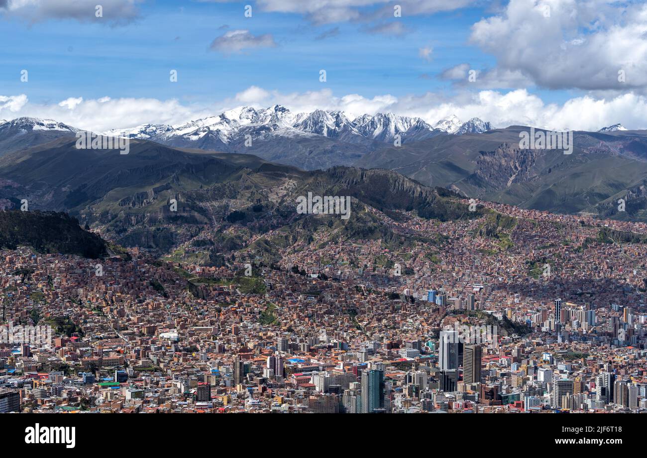 Breathtaking aerial view of town located in mountainous valley with scenic rocky jagged cliffs on sunny day in La Paz Stock Photo