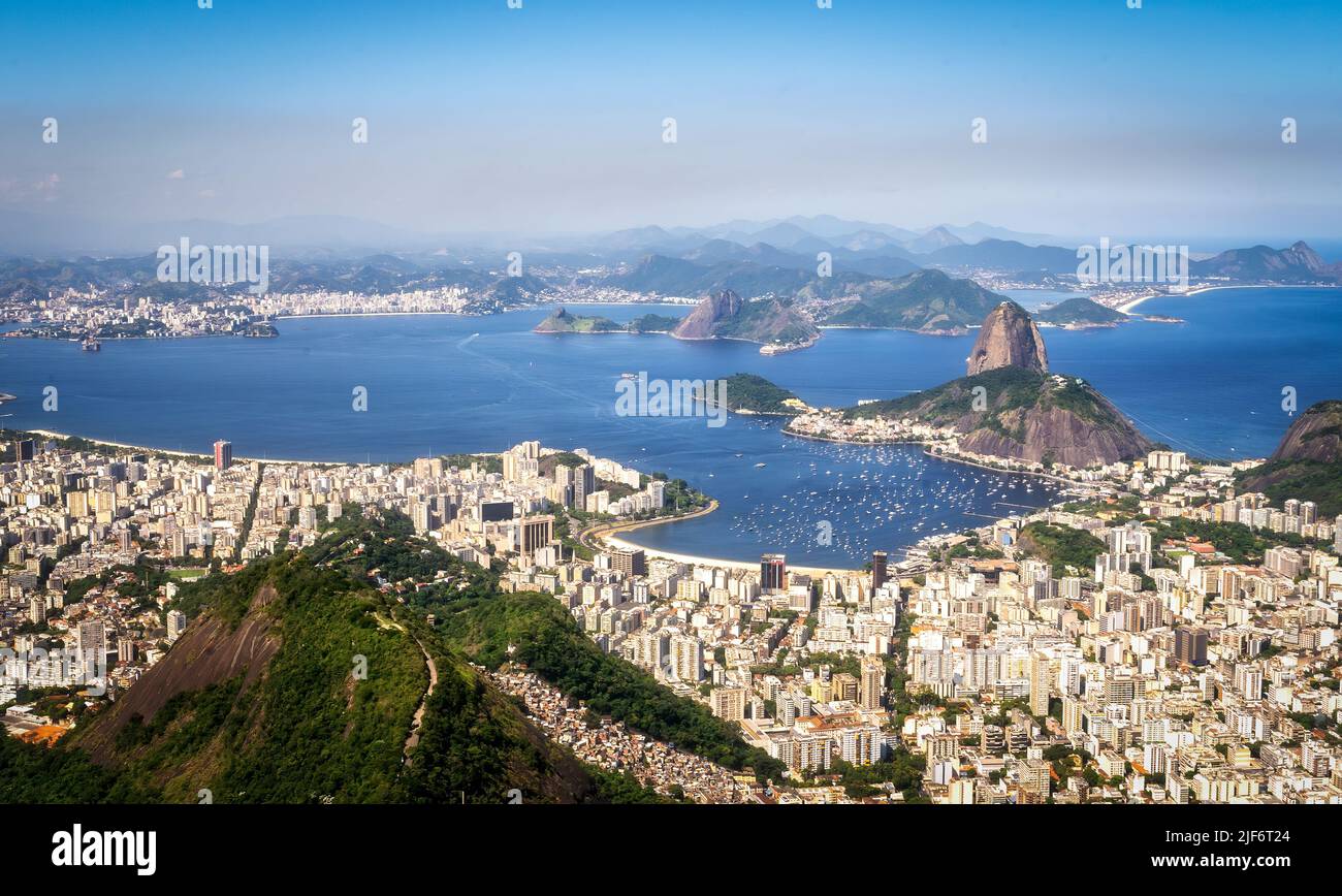 Breathtaking scenery of modern city above ocean and mountains against amazing sunset sky in Rio de Janeiro Stock Photo