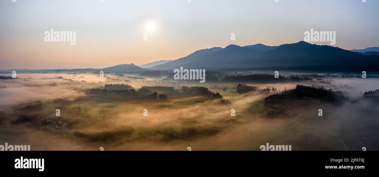Sunset Panorama with drone at the Bavarian Alps. Mist and fog at the ground Stock Photo