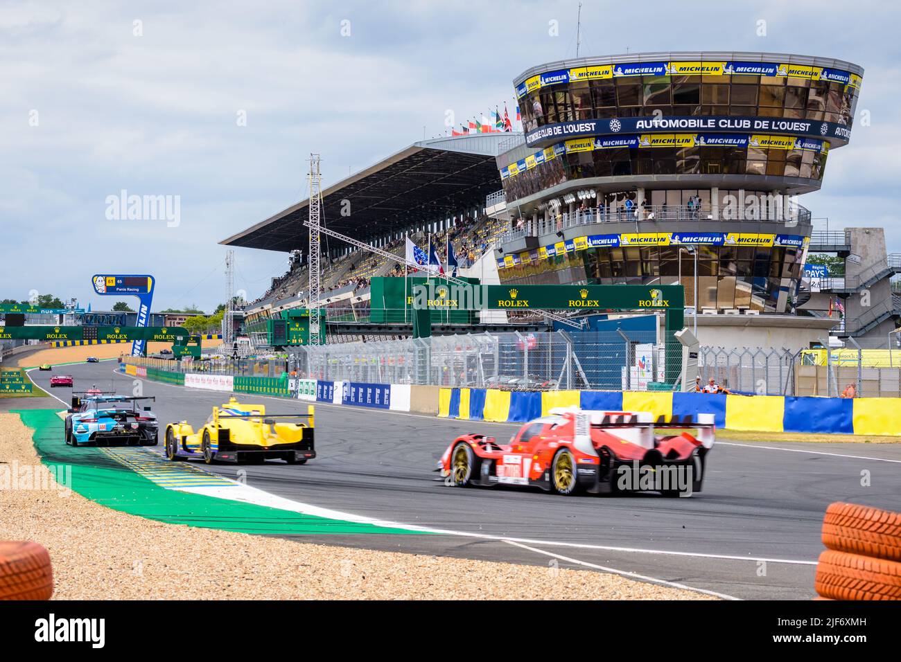 Prototype and GT race cars drive in the pit straight on the Circuit de la Sarthe racetrack during the 24 hours of Le Mans. Stock Photo