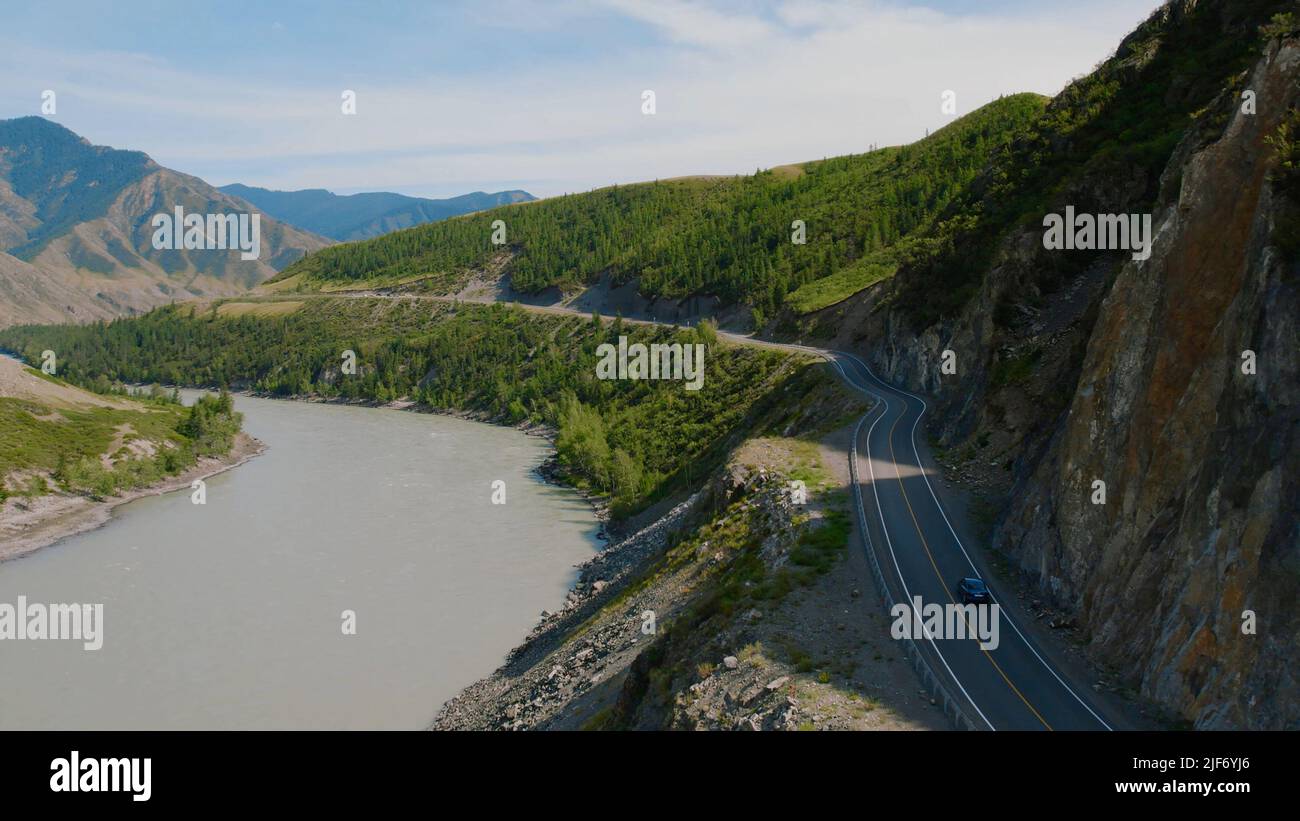 Cars on Chuya highway road between mountains and Katun river in Altai, Siberia, Russia. Beautiful summer nature landscape at during daytime. Aerial vi Stock Photo