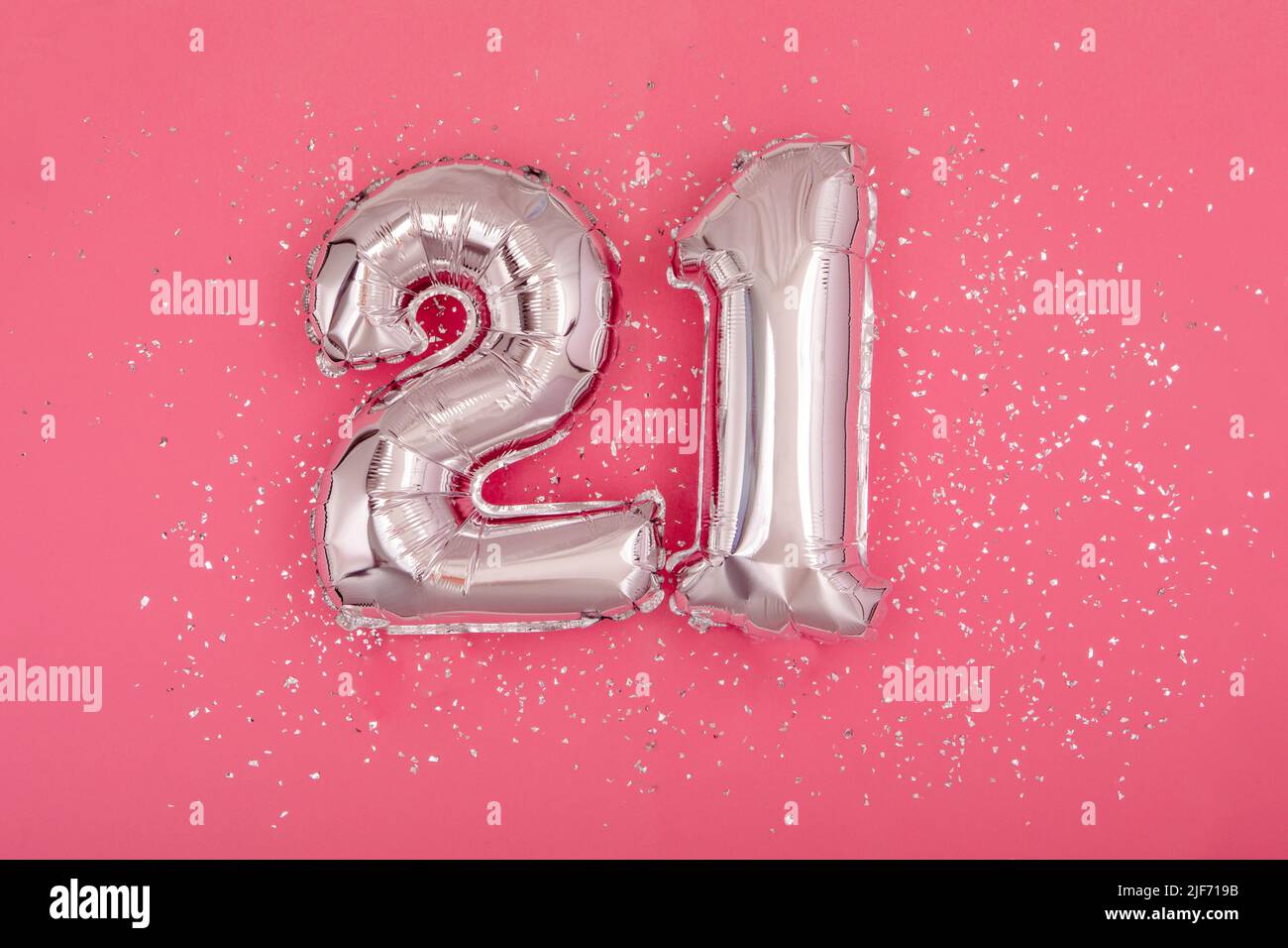 Silver balloon shape of number twenty one 21 pink background Stock Photo