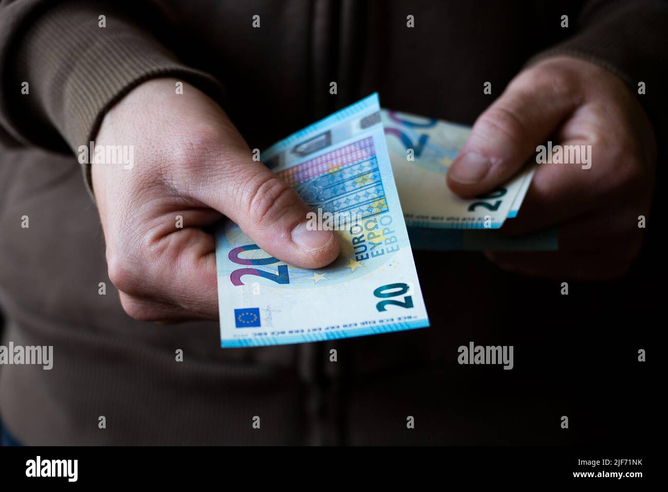White man giving Euro paper money twenty bills closeup Stock Photo