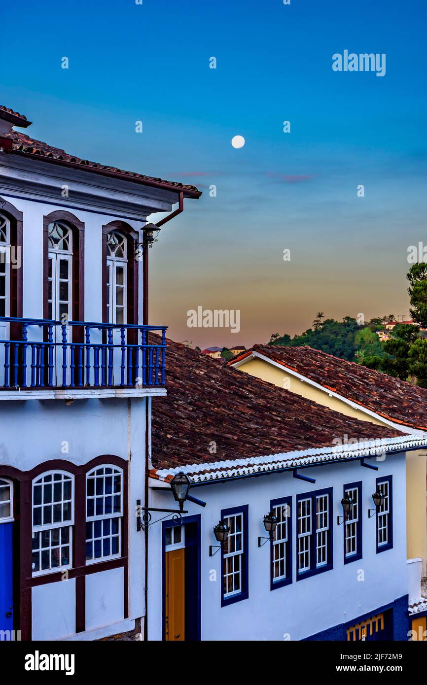Nightfall in the historic city of Ouro Preto in the state of Minas Gerais with the full moon in the sky and the facade of old colonial style houses Stock Photo