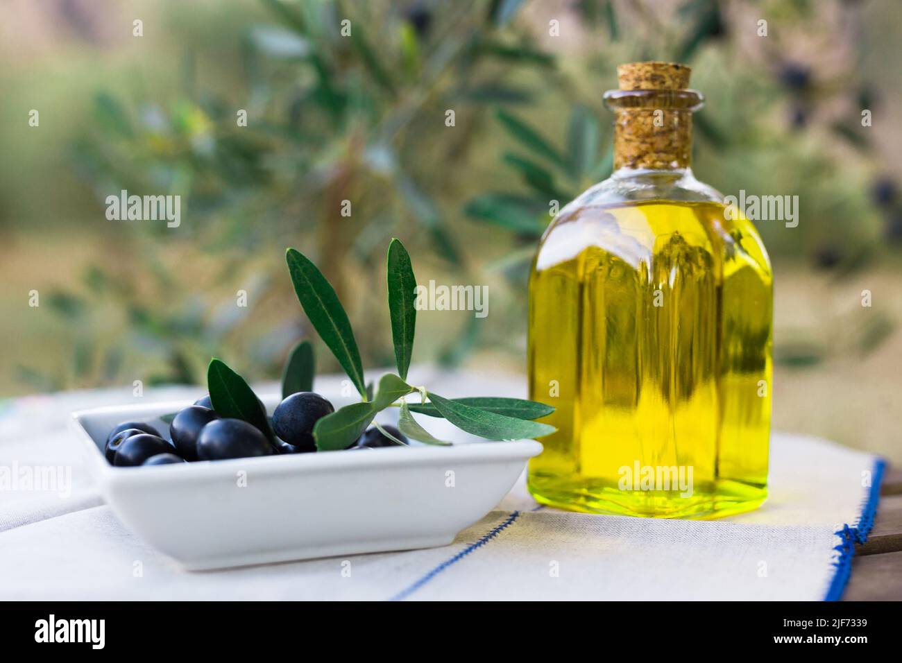 still life of olives and oil on a table against a background of olive