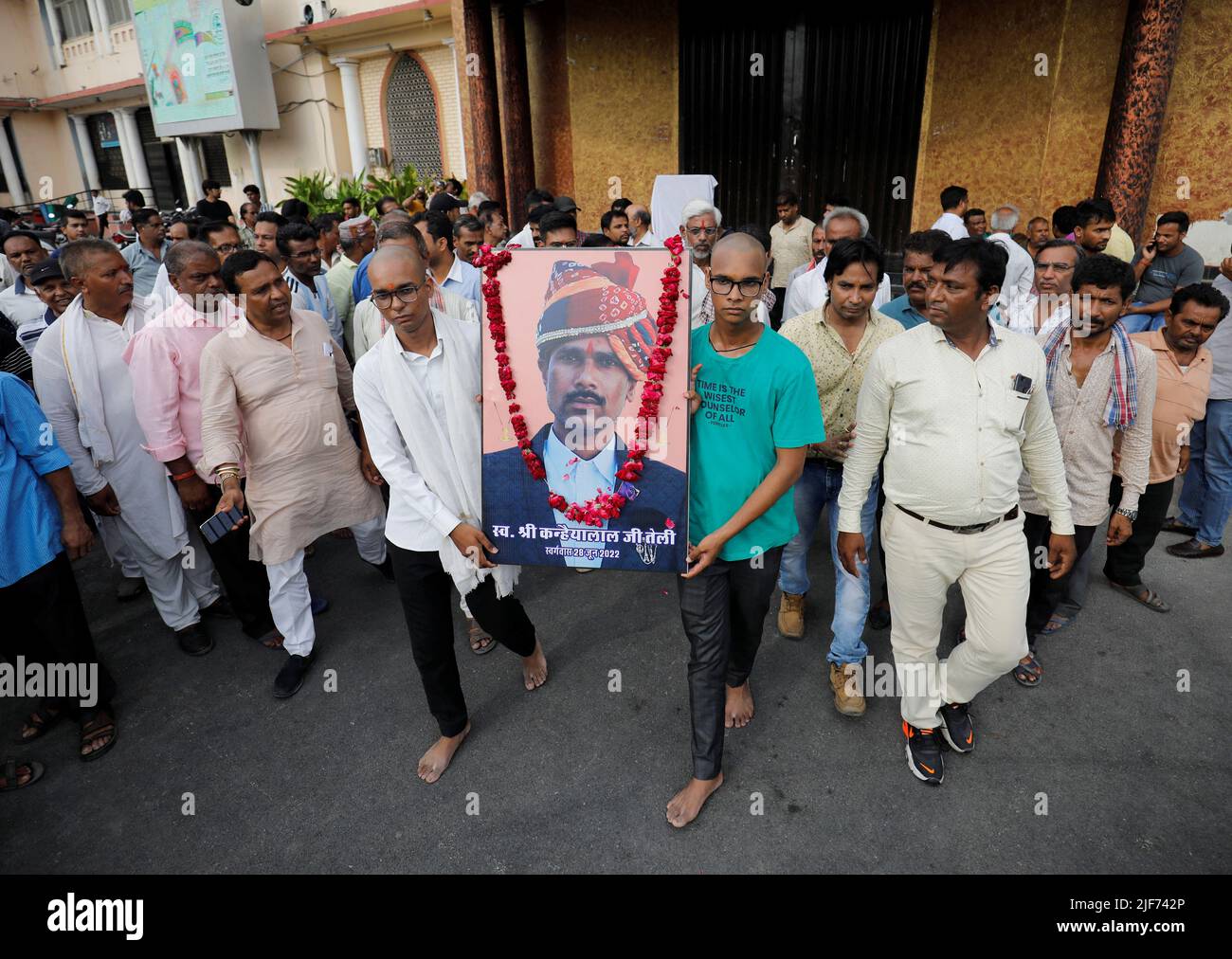Two sons of Kanhaiyalal Teli, a Hindu tailor, who was killed by two suspected Muslims after they videoed themselves slaying him, carry a portrait of their father after a prayer meeting in Udaipur in the northwestern state of Rajasthan, India, June 30, 2022. REUTERS/Amit Dave     TPX IMAGES OF THE DAY Stock Photo