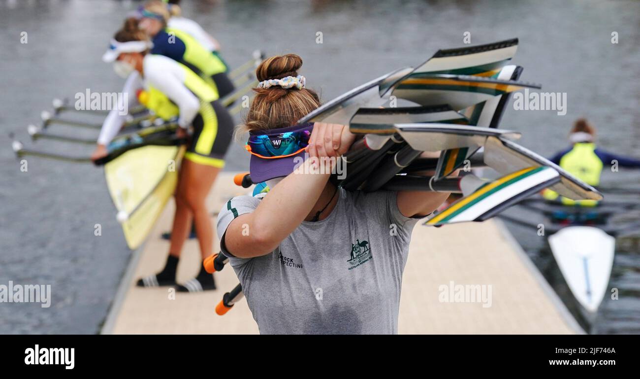 An Australian female rowing crew bring their oars and boat ashore during the 2022 Henley Royal