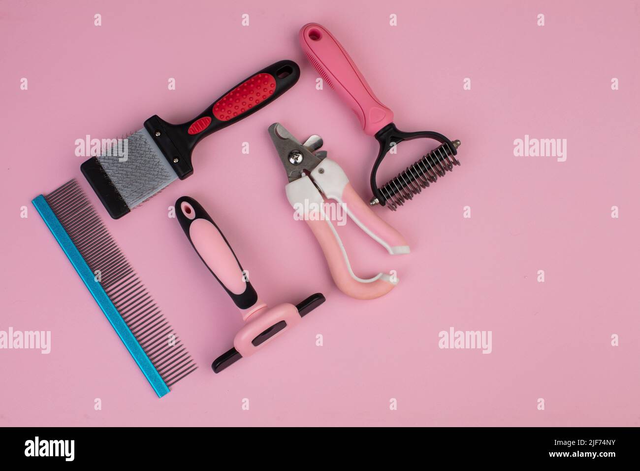 Tool for the groomer on a pink background. Dog grooming accessories
