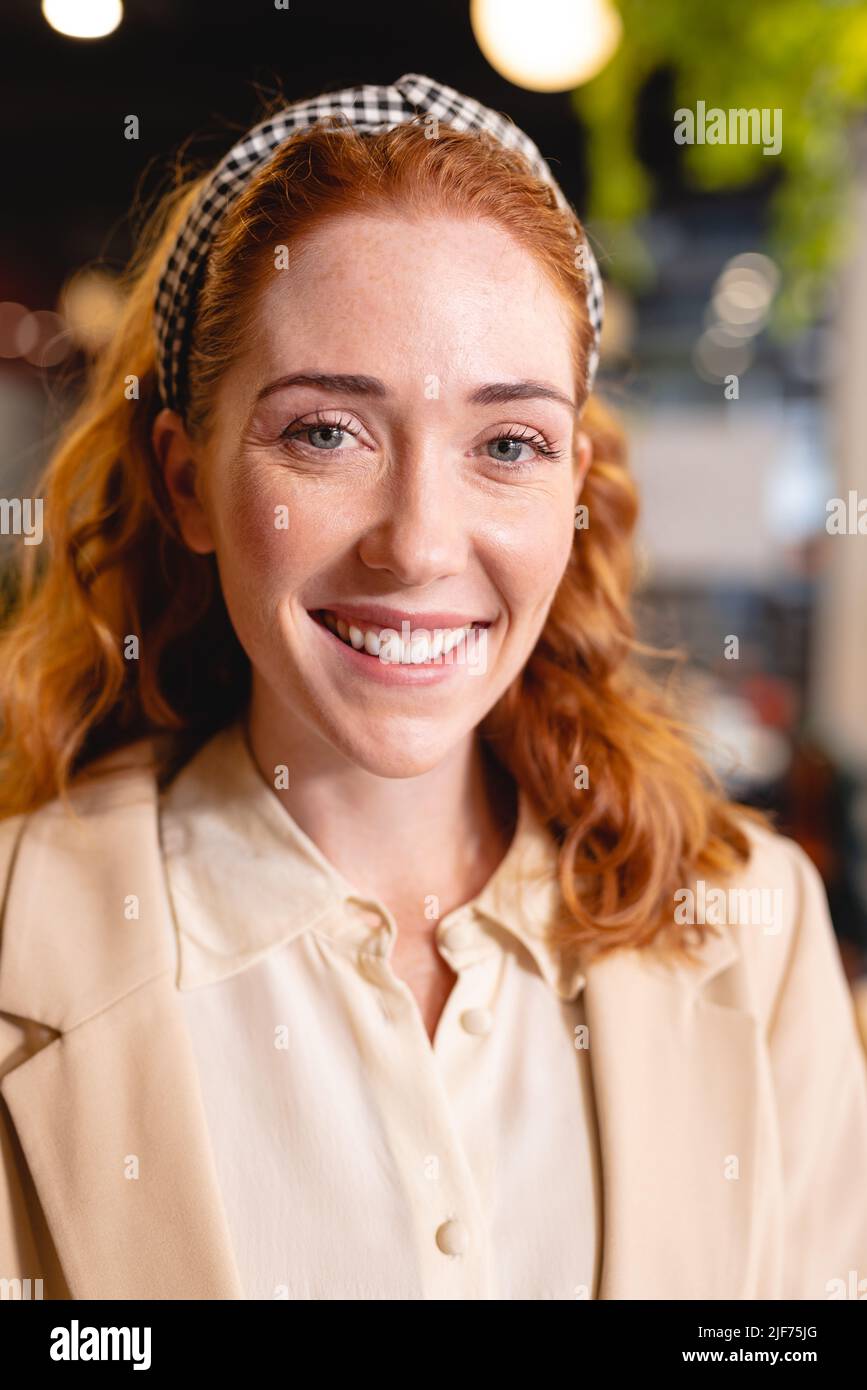 Portrait of smiling caucasian young businesswoman at workplace Stock Photo