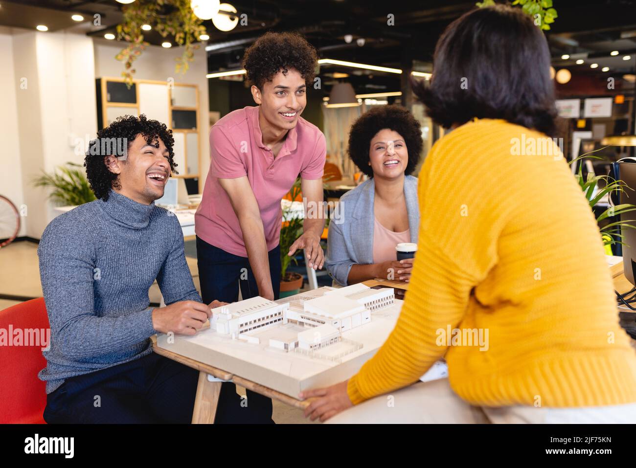 Smiling multiracial male and female architects discussing over ...