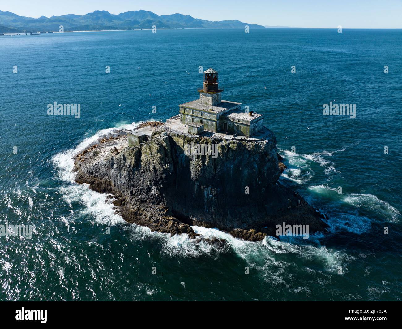 The cold water of the Pacific Ocean surrounds the historic, deactivated Tillamook Rock Lighthouse off the scenic Oregon coast. Stock Photo