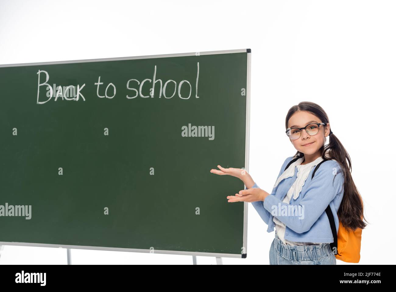 Schoolchild in eyeglasses pointing at chalkboard with back to school ...