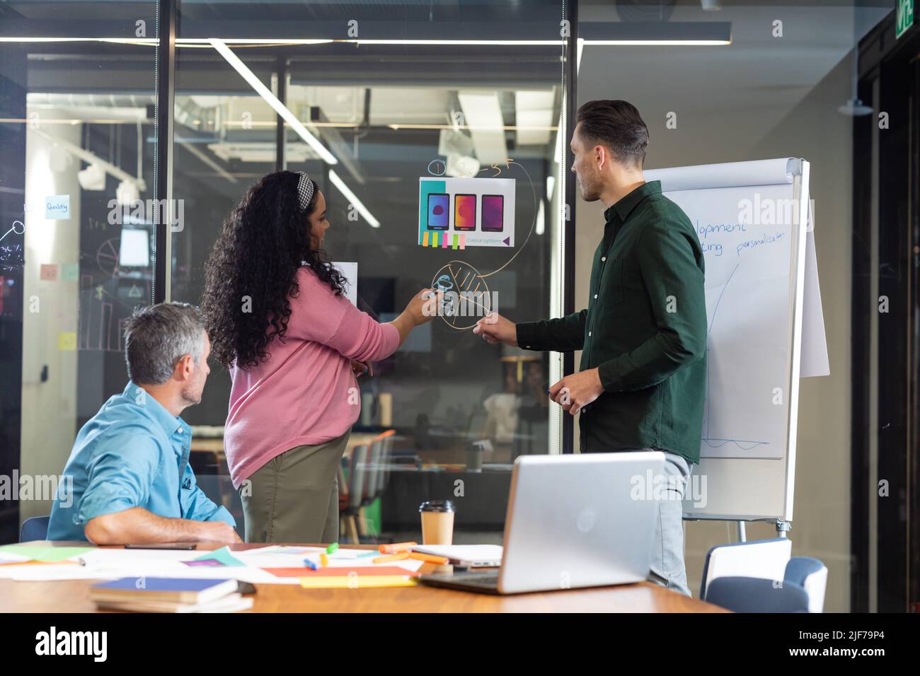 Multiracial colleagues explaining business plan to manager over diagram in meeting Stock Photo