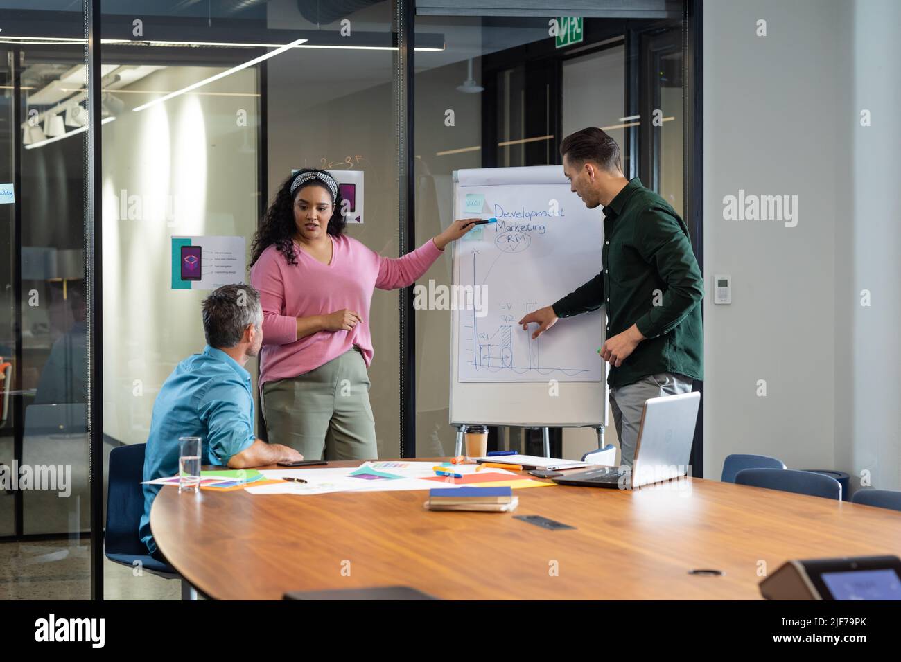 Multiracial colleagues explaining business plan to manager over flipchart in meeting Stock Photo