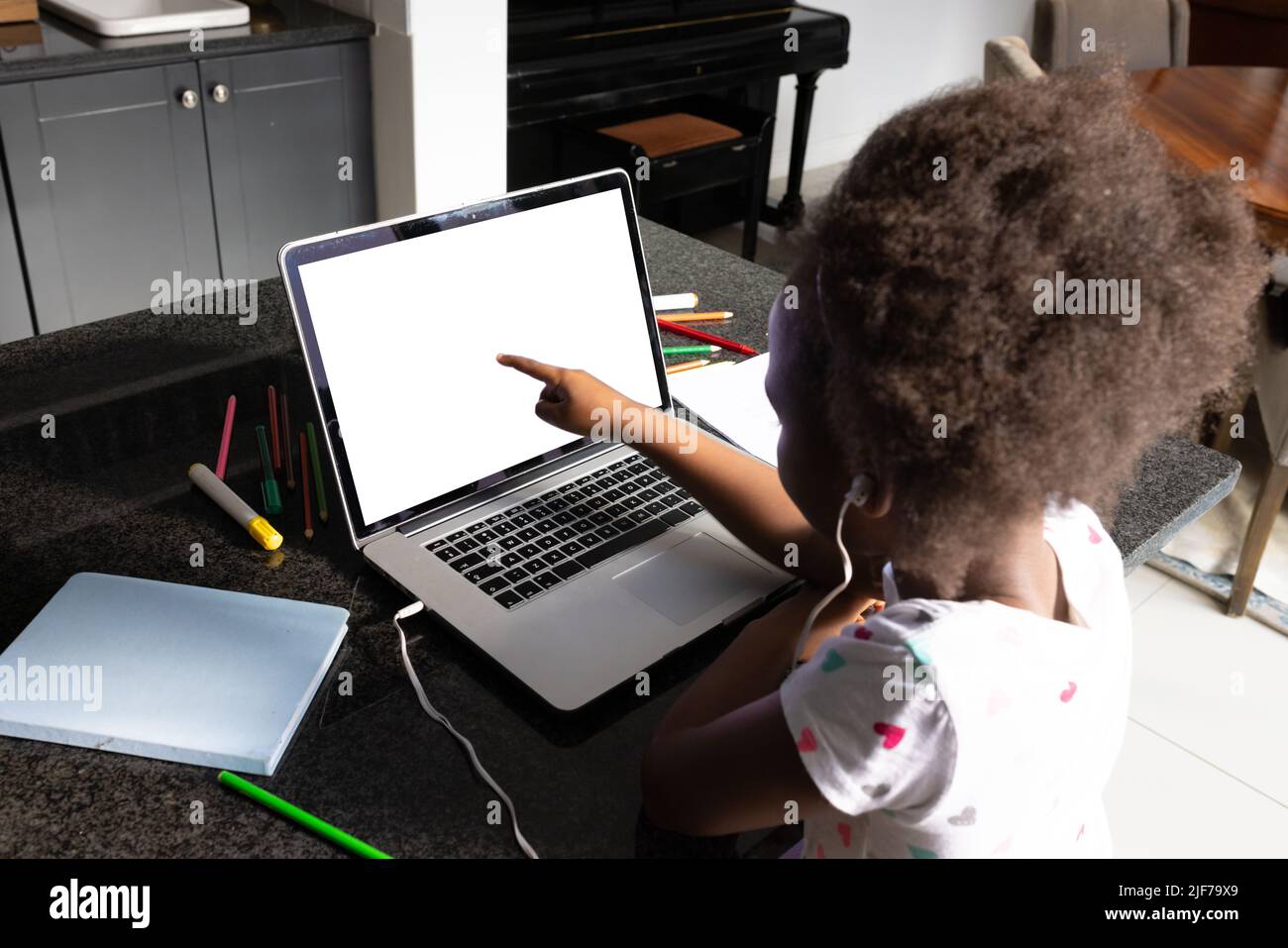 African american girl with afro hair pointing at laptop while studying ...