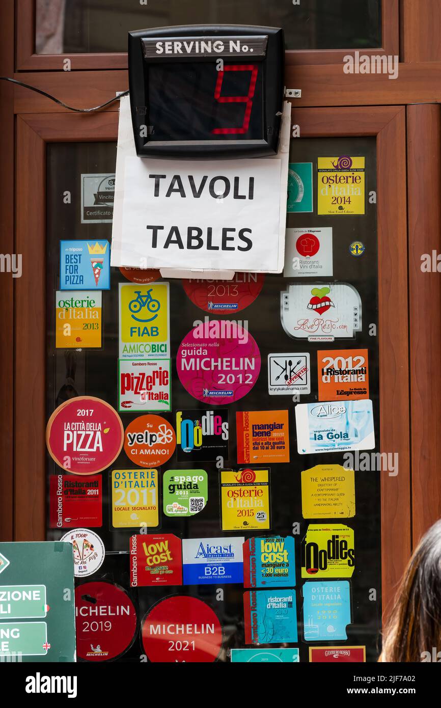 Naples, Italy. May 27, 2022. Waiting number display above the window filled with award tickets in the famous L'antica Pizzeria da Michele in Naples, I Stock Photo