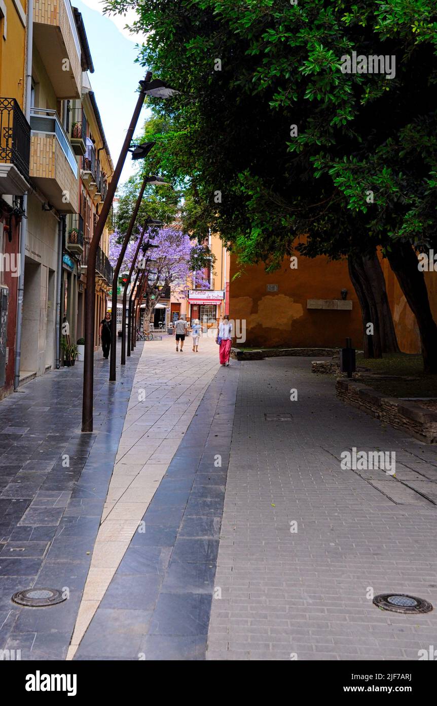 fußgängerzone in denia mit leuten, baum, kopfsteinpflaster, pedestrian zone with people and cobblestone pavement Stock Photo