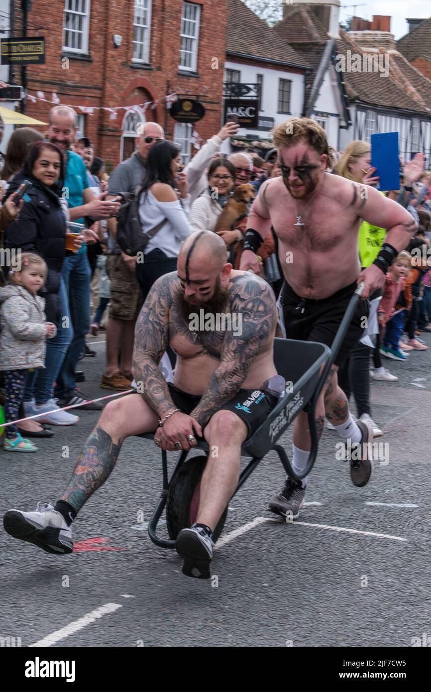 The bare-chested wheelbarrow race winners completing the course in record time at St Georges’ Day Celebration Pinner, Harrow, North West London. Stock Photo