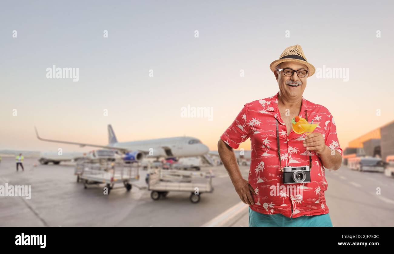 Happy mature male tourist posing on an airport apron Stock Photo