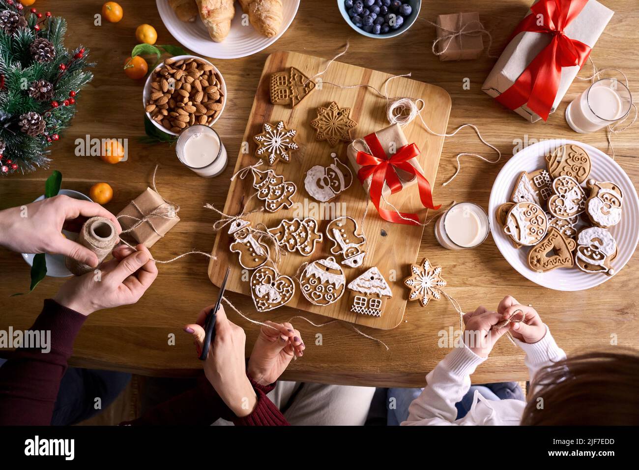 Top view of family and kid daughter making family xmas tree holiday decorations. Stock Photo
