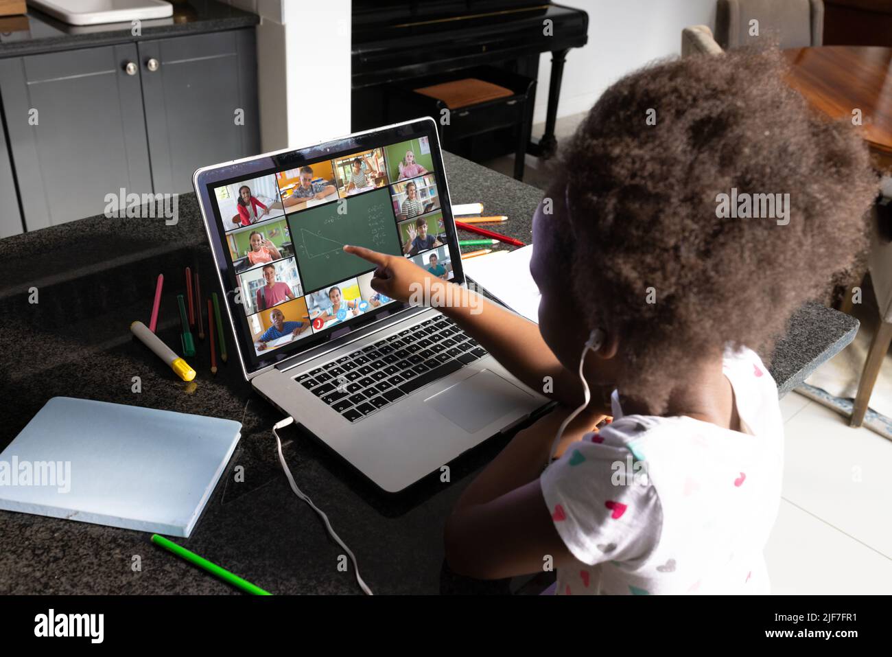 African american girl with afro hair pointing at laptop screen while ...
