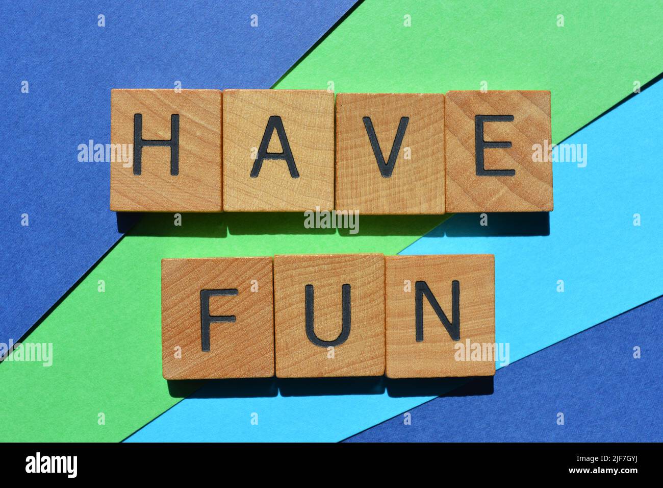 Have Fun, words in wooden alphabet letters isolated on colorful background Stock Photo
