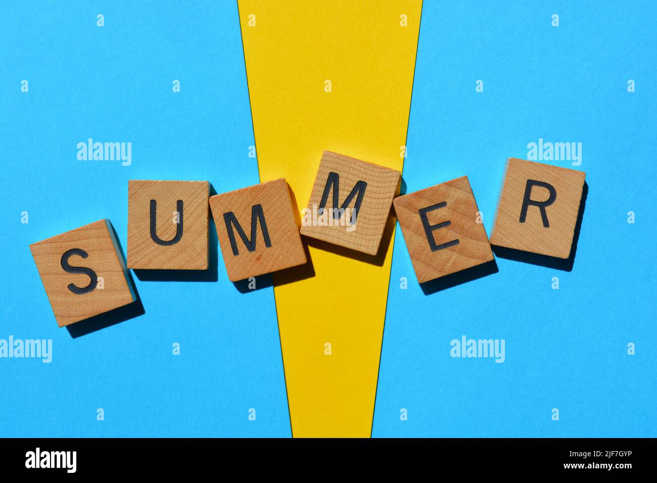 Summer, word in wooden alphabet letters isolated on yellow and blue background Stock Photo