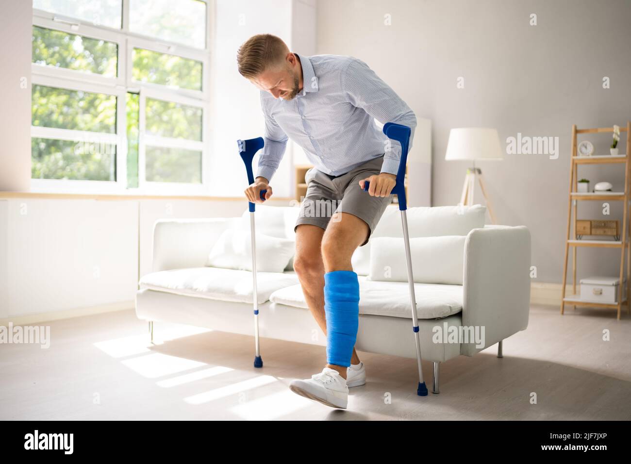 Man With Broken Leg After Accident Using Crutches Stock Photo